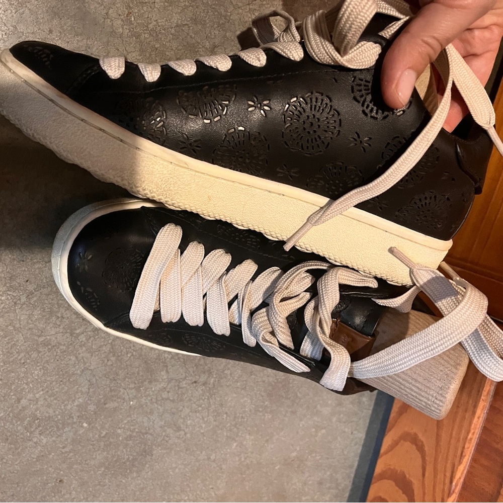 Black leather Coach sneakers with embossed floral print, detachable coach tags